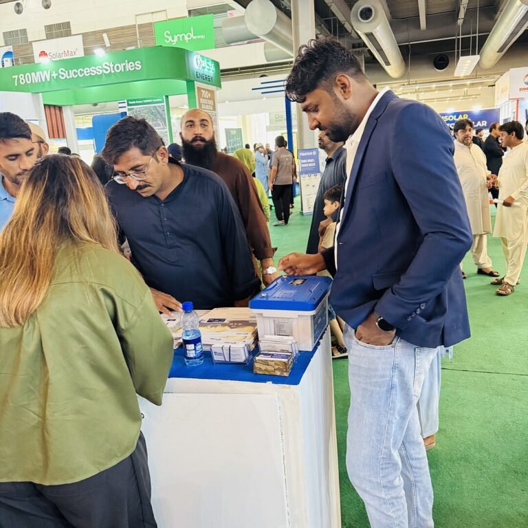 SNM Solutions team looking at a lithium battery at a solar expo
